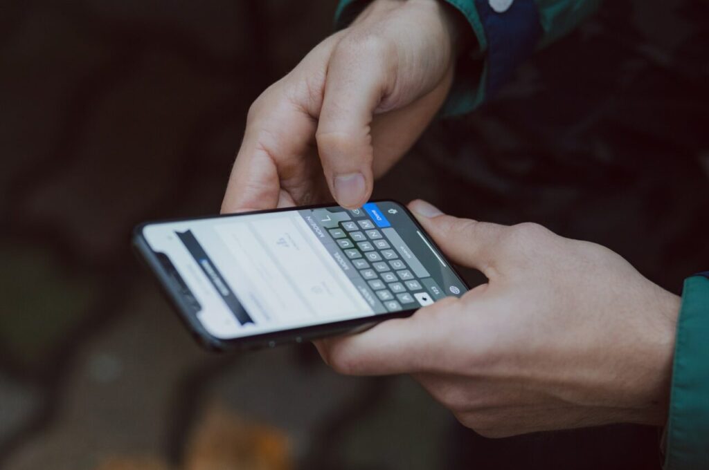 Hands typing on a cell phone