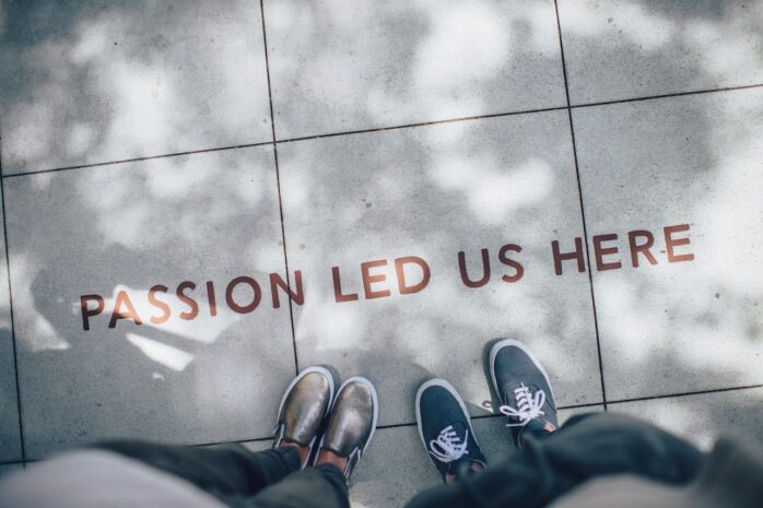 Floor with text showing "Passion led us here" and 2 people's shoes