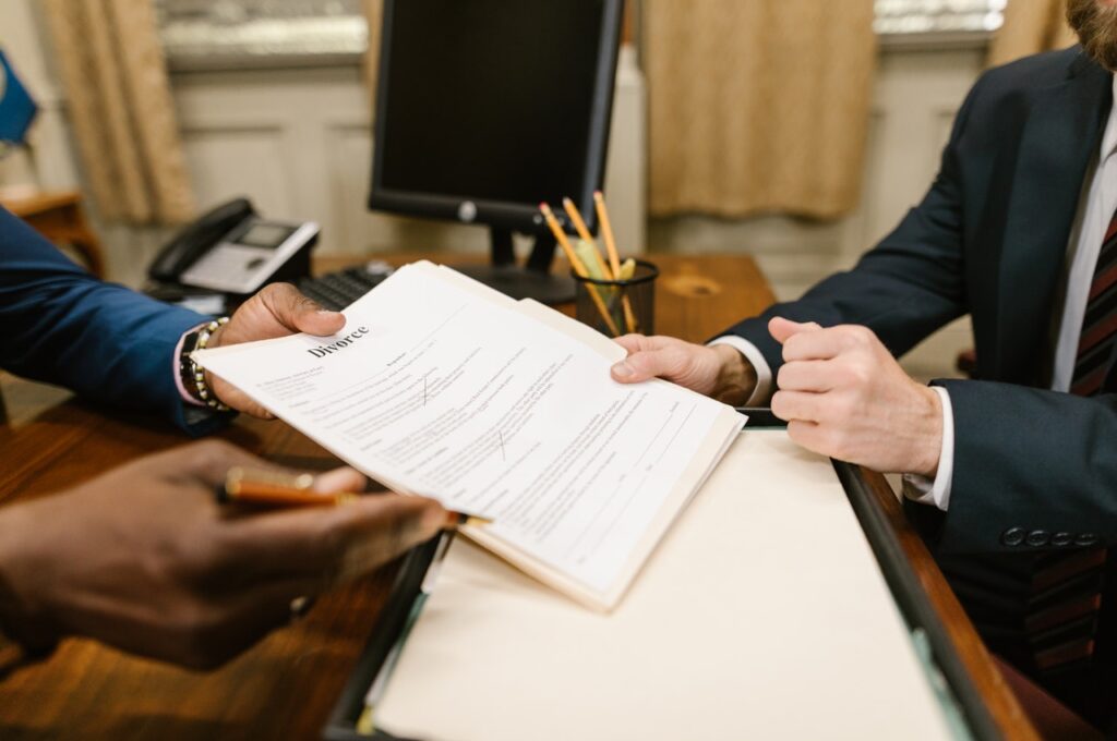Two men on a desk holding a paper