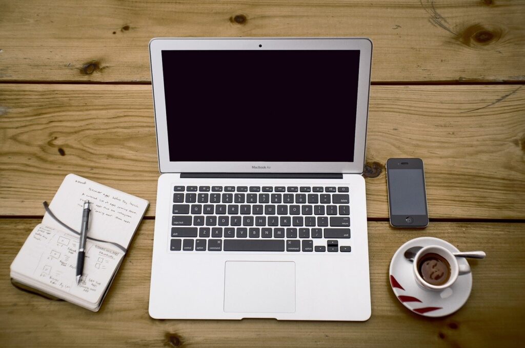 Laptop, notebook, phone and cup of coffee on a table