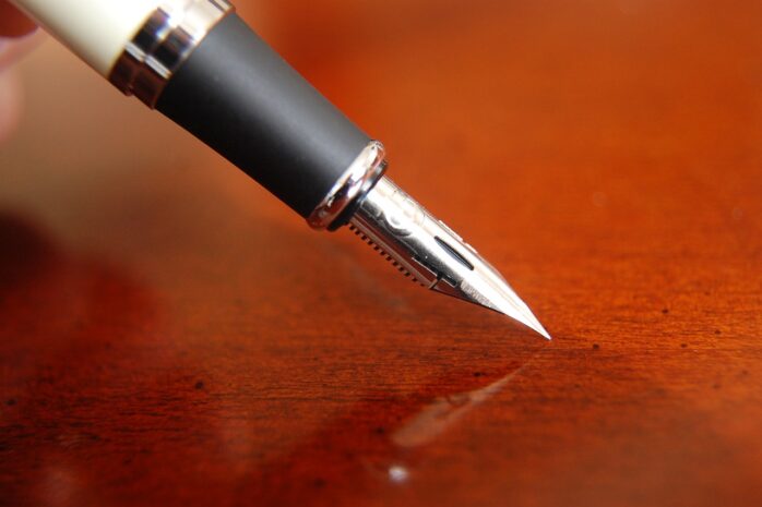 a pen in the process of writing a signature